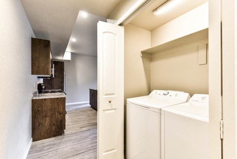 a washer and dryer in a laundry room with a counter and a kitchen